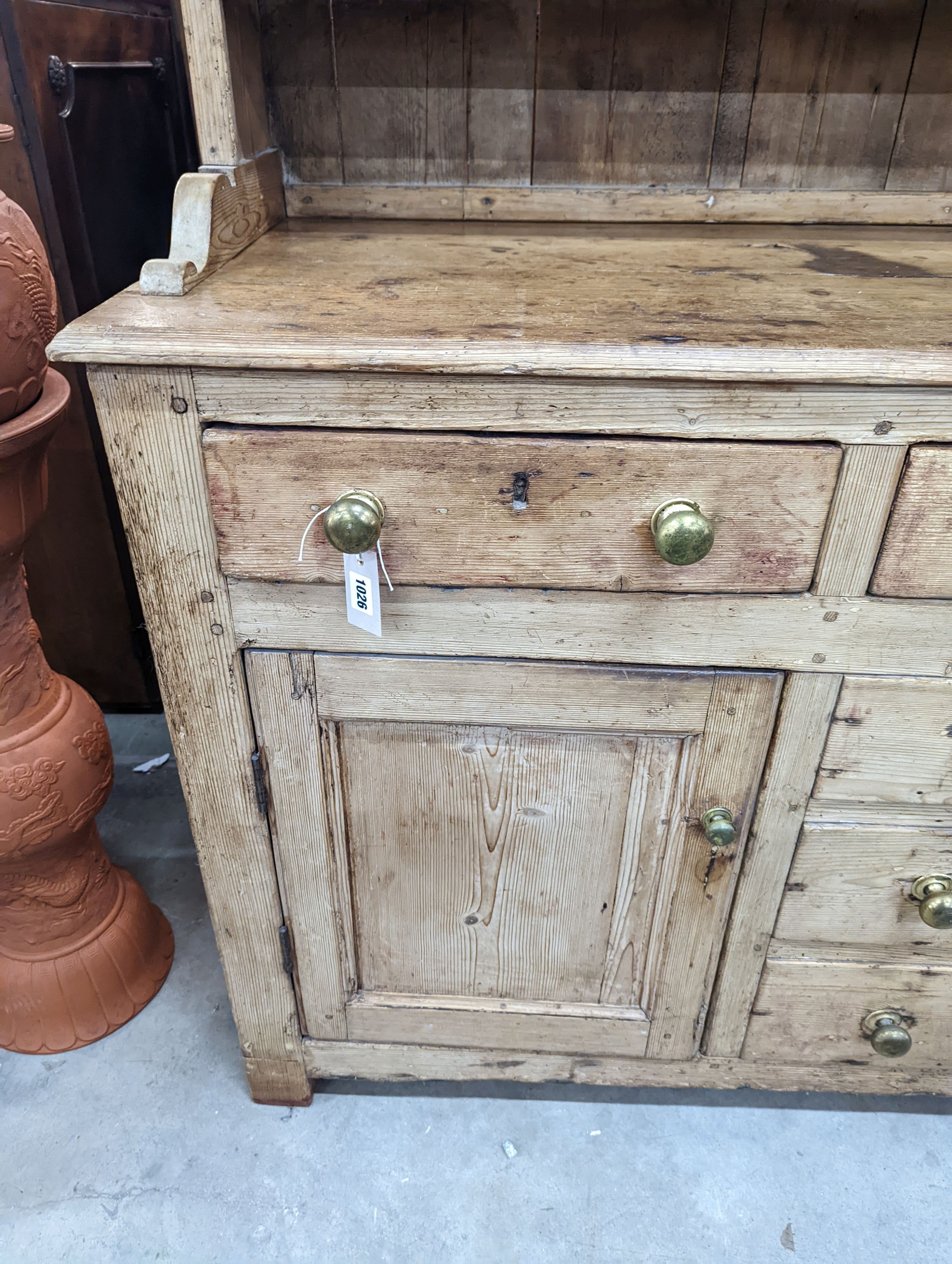 An early 19th century pine dresser with boarded rack, width 141cm, depth 49cm, height 206cm